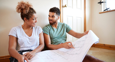 A couple looking over home improvement blueprints