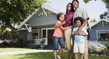 Happy family in front of home