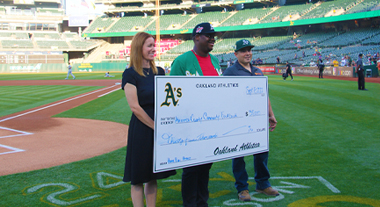 Presenting a check to Alameda County Community Food Bank during an A's game.