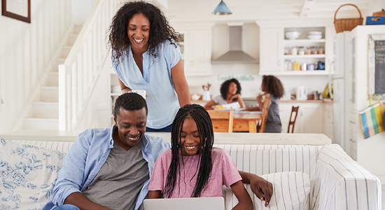 Parents helping teen open checking account via laptop