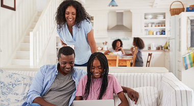 Teen opening an account on her laptop with her parents