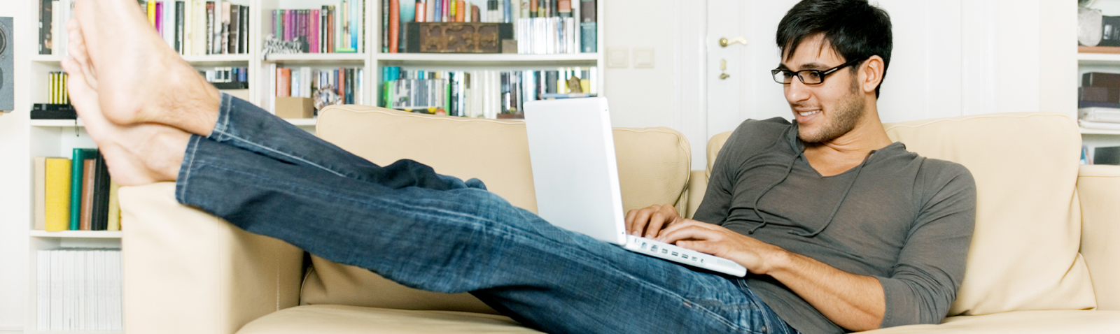 Person on couch checking laptop