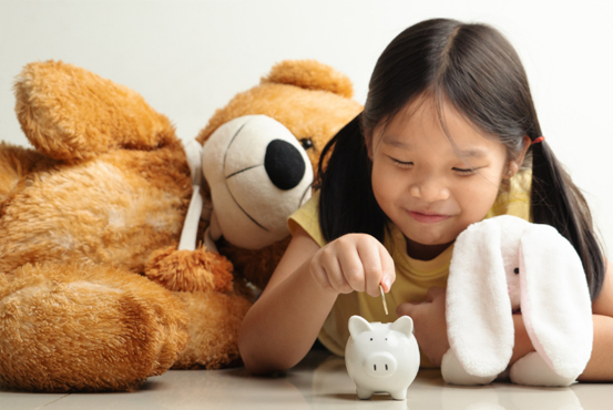 Young person putting money in piggy bank