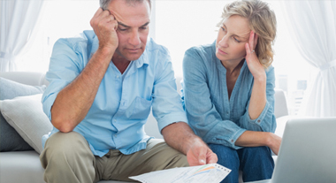 Concerned couple reading bills