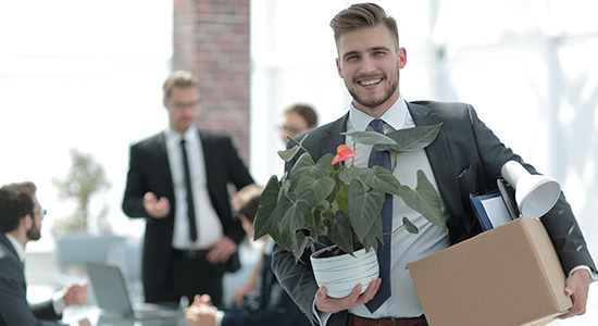 Leaving the office with a plant and box of belongings