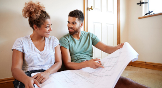 A couple looking over home improvement blueprints