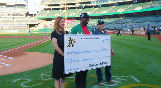 Presenting a check to Alameda County Community Food Bank during an A's game.