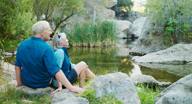 Retired couple relaxing by a stream