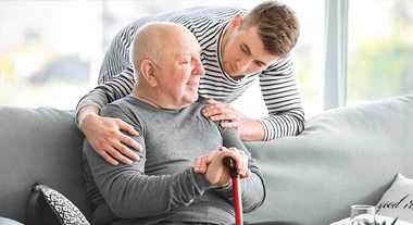 Younger family member speaking with elderly grandfather